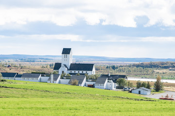 Cityscape of Skalholt in Iceland during day in golden circle with small town village and houses buildings with green grass