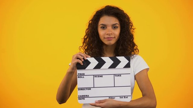 Shocked producer assistant saying Wow and using clapper board, shooting movie