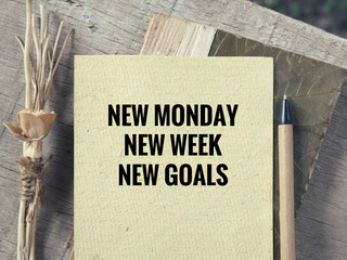 Motivational and inspirational wording - New Monday, New Week, New Goals written on a paper. Blurred styled background.