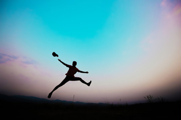 Fototapeta na wymiar silhouettes; a man jumping in the sky