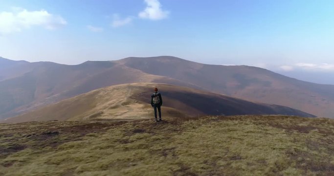 Aerial view: Epic flight along man with beautiful mountains background. 4k