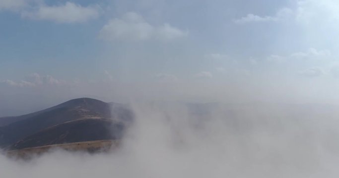 Aerial view: Flying in the fog over amazing mountains. 4k