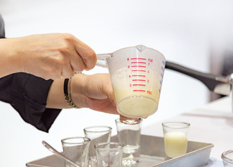 Measuring out milk in a measuring jug for cooking or test