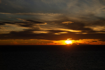 Dark Golden Sunset over Deep Blue Sean and Cloudy Sky