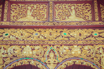 Beautiful craved Buddha with animals in forest patterns on the gables of the Thai's northern style church at Wat Chedi Liam, one of the ancient temple in Wiang Kum Kam archaeological area, Chiang Mai.