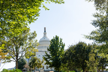 US Congress dome closeup with sky in Washington DC, USA on Capital capitol hill and construction workers painting exterior on scaffold scaffolding statue