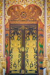Beautiful golden craved angels in Thai's style church entrance door. Selective focus