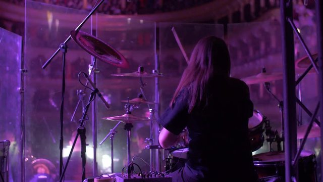hairy drummer playing on stage of opera house