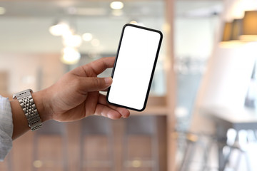 Blank screen mobile smart phone in male hand over office background