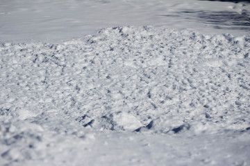 Close-up view of snow textures featured in deep banks of shoveled snow