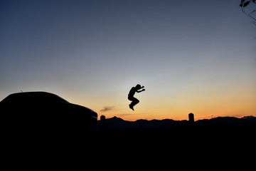 Fototapeta na wymiar Silhouette of a jumping man at sunset, Concept lifestyle freedom vacation travel.