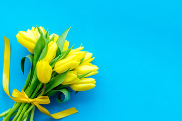 Spring composition. Bouquet yellow tulips on blue background top view copy space