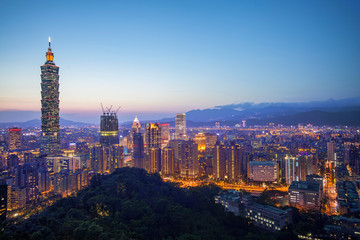 Fototapeta premium Kolor pejzaż z wieżowcem i budynkami pod błękitnym niebem w nocy w Tajpej na Tajwanie