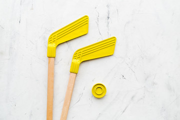 Ice hockey stick and puck on white stone background top view copy space