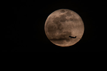 Full moon with a plane passing by