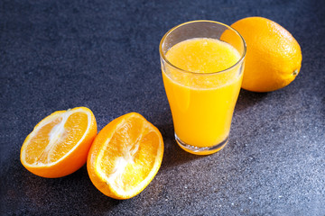 Glass of orange juice and fresh fruits on table of kitchen. Healthy drink. Dieting food.