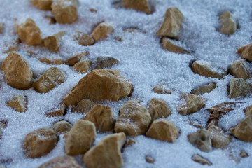 Abstract design background of macro photographed partially snow covered rocks with texture