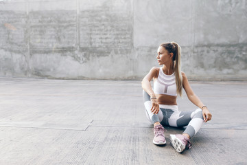 Fitness sport model in fashion sportswear posing over gray wall - obrazy, fototapety, plakaty