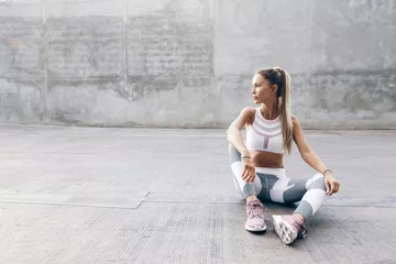 Fotobehang Fitness sport model in fashion sportswear posing over gray wall © Alena Ozerova