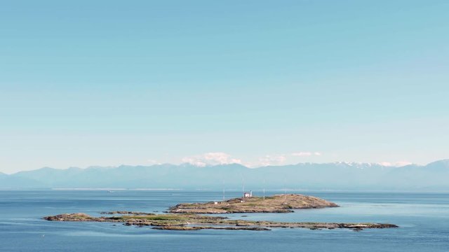 Trial Islands, Salish Sea, Victoria 4K UHD. The lighthouse on the Trial Islands, near Victoria on Vancouver Island. The Olympic Mountain range, in Washington State, is in the background. 4K. UHD.