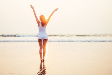 freedom and woman independence concept.Happy young girl on the tropical beach.Happy female model during summer vacation enjoying the sea breeze and fresh air.spf and sun block spa