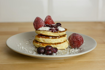  golden cheesecakes with blueberry jam and strawberries