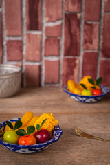 Thai desserts on a plate of white and blue stripes placed on wood table there are Similar object and water bowl place on the backside and fork placed beside.