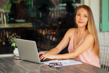 girl sitting on lounger with a laptop by the sea in the resort. beautiful business woman have a seasonal winter vacation on the beach in exotic country