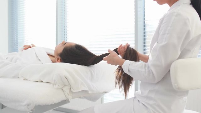 Beauty and cosmetology image of young woman face having face massage in spa salon. Stimulating cell regeneration and the production of collagen with elastin