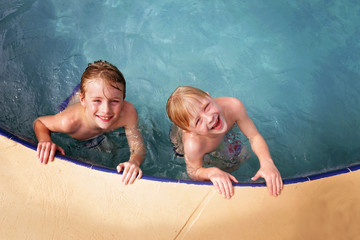 Happy Little Kids Smiling as They Swim in the Family Swimming Pool
