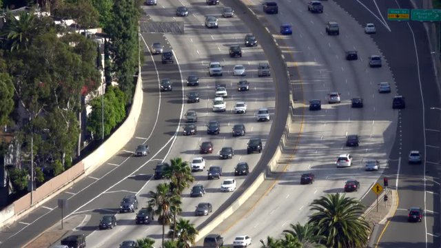 Vehicular traffic is shown, from an elevated view, on the 101 freeway running through Hollywood during the afternoon.