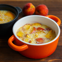 Delicious pudding with peach in casserole, closeup