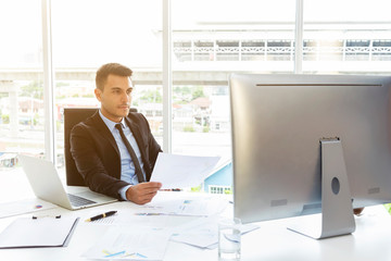 Smart businessman working with paper work report and computer in office. Modern technology for work.