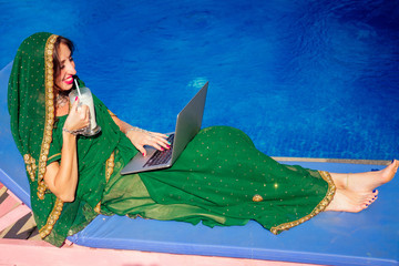 remote working concept job.beautiful and young indian woman in green stylish sari toothy white...