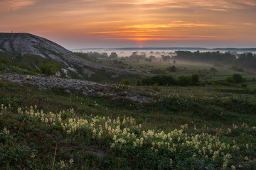Fototapeta na wymiar Beautiful sunrise over hills and meadow
