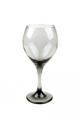 Empty smoked grey wine glass over a white background