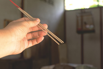 Burning incense in hand of woman.Close up