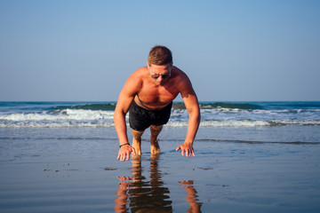 Muscular man during workout on the summer beach