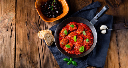 Baked mini meatballs in tomato sauce with basil