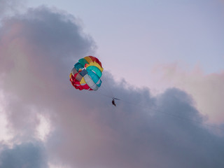 Parasailing in evening. Bright parachute on a background of a sunset