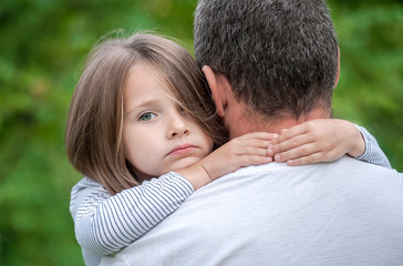 Portrait of one sad daughter hugging her father
