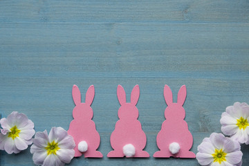 Bord&uuml;re aus 3 rosa Hasen mit weissen Schw&auml;nzen undhell lia Bl&uuml;ten auf Hintergrund aus blau gebeiztem Holz grosses Textfeld Vintage