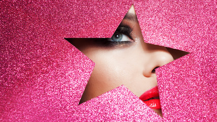 Bright makeup and you're a star. Beautiful girl close up, paper in the shape of a star.