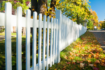 Beautiful colorful autumn scene with white fence and fall colors in Finland.