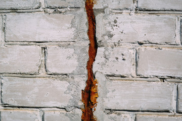 Crack on an old white brick wall, texture abstraction