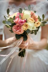 the bride in a dress before the wedding reception waiting for the groom holding a bouquet. close up.