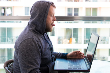 Cybercrime, hacking and technology concept - male hacker writing code or using computer virus...