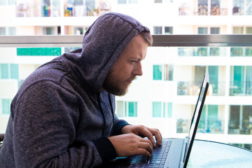Cybercrime, hacking and technology concept - male hacker writing code or using computer virus...