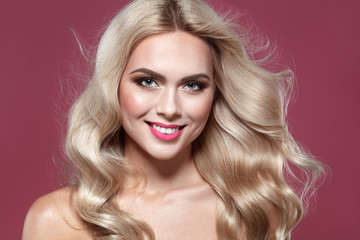 Naklejka premium Spring make up. Purity Blonde haired Woman Portrait with blue eyes and Healthy Long Shiny Wavy hairtyle. Volume shampoo. Blond Curly permed Hair and bright makeup. Beauty salon and haircare concept.