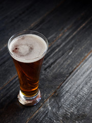 A glass of beer on a dark wooden table